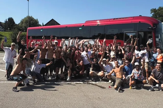 Il gruppo 2025 davanti al pullman rosso, con le braccia alzate