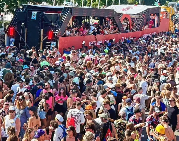 La folla della Street Parade davanti a un carro rosso, dal viaggio 2025