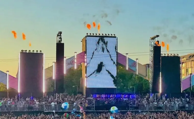 Il palco della Street Parade di Zurigo al tramonto, con le fiamme e la folla