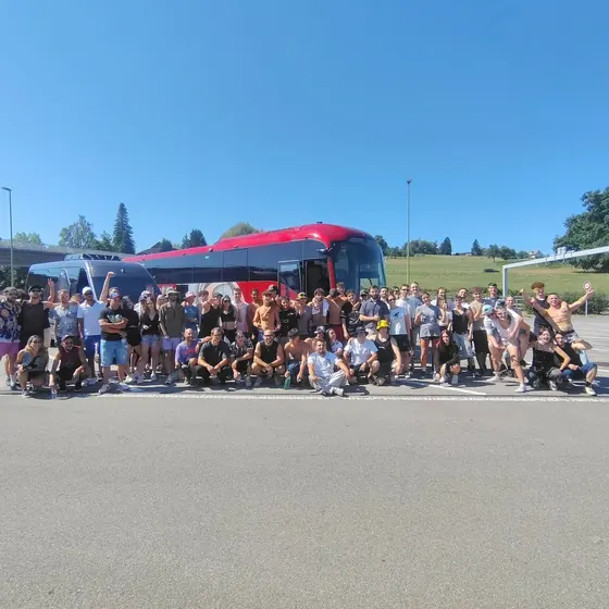 Il gruppo 2026 davanti al pullman rosso e al pulmino