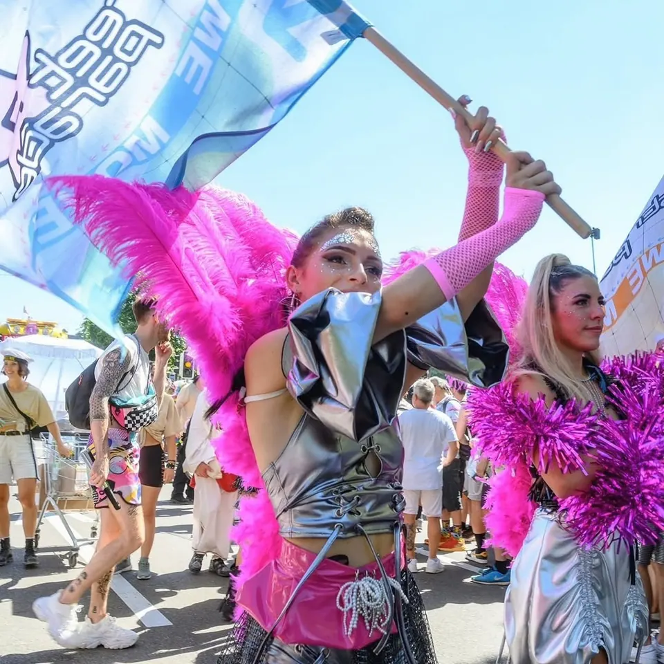 Ragazza con le ali rosa e una bandiera alla Street Parade